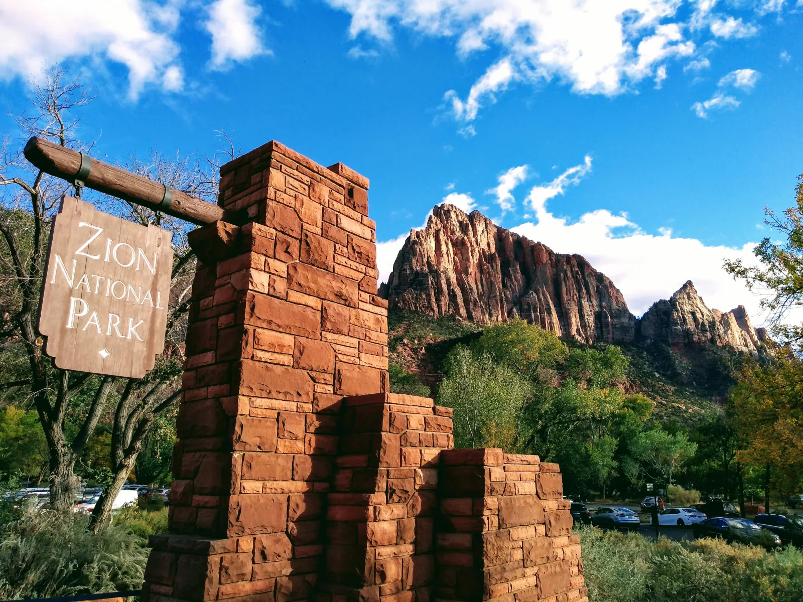 Stone Zion National Park entrance pillar with red cliffs in the background