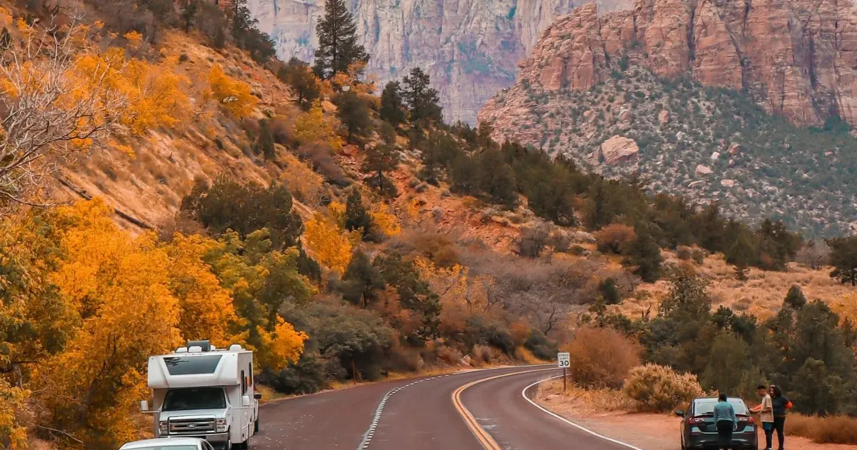 Vehicles pulled over at a roadside viewpoint inside Zion National Park in autumn